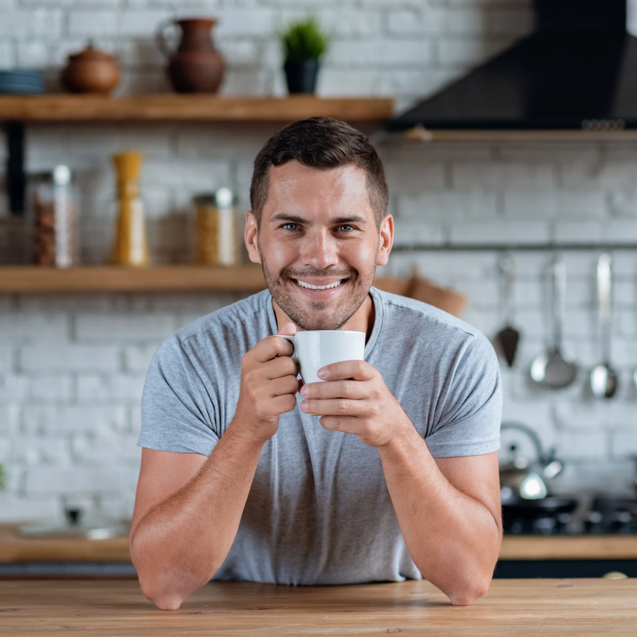 man smiling with a cup of coffee after teeth whitening